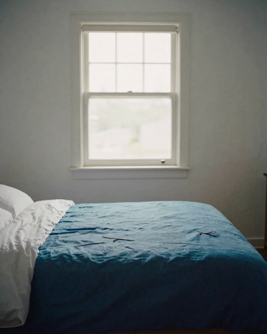 Natural daylight falling across a calm, uncluttered bedroom with linen bedding and a window open to morning light, quiet